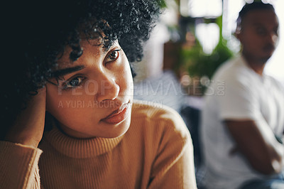 Buy stock photo Shot of a young woman looking upset after an argument with her partner at home