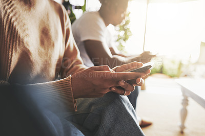 Buy stock photo Closeup shot of an unrecognisable couple using their digital devices at home