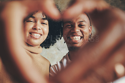 Buy stock photo Portrait of a young couple making a heart shape with their hands