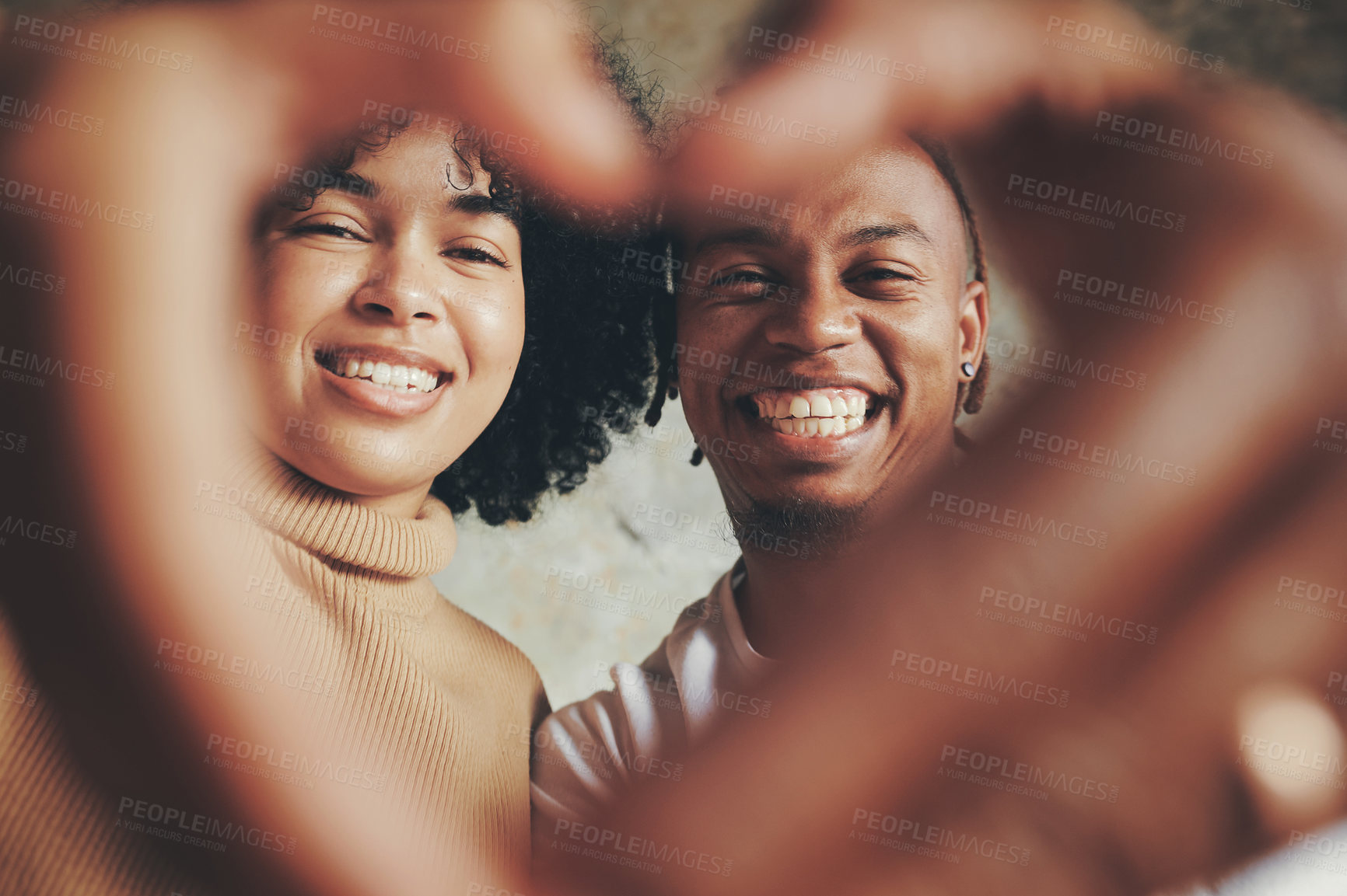Buy stock photo Portrait of a young couple making a heart shape with their hands