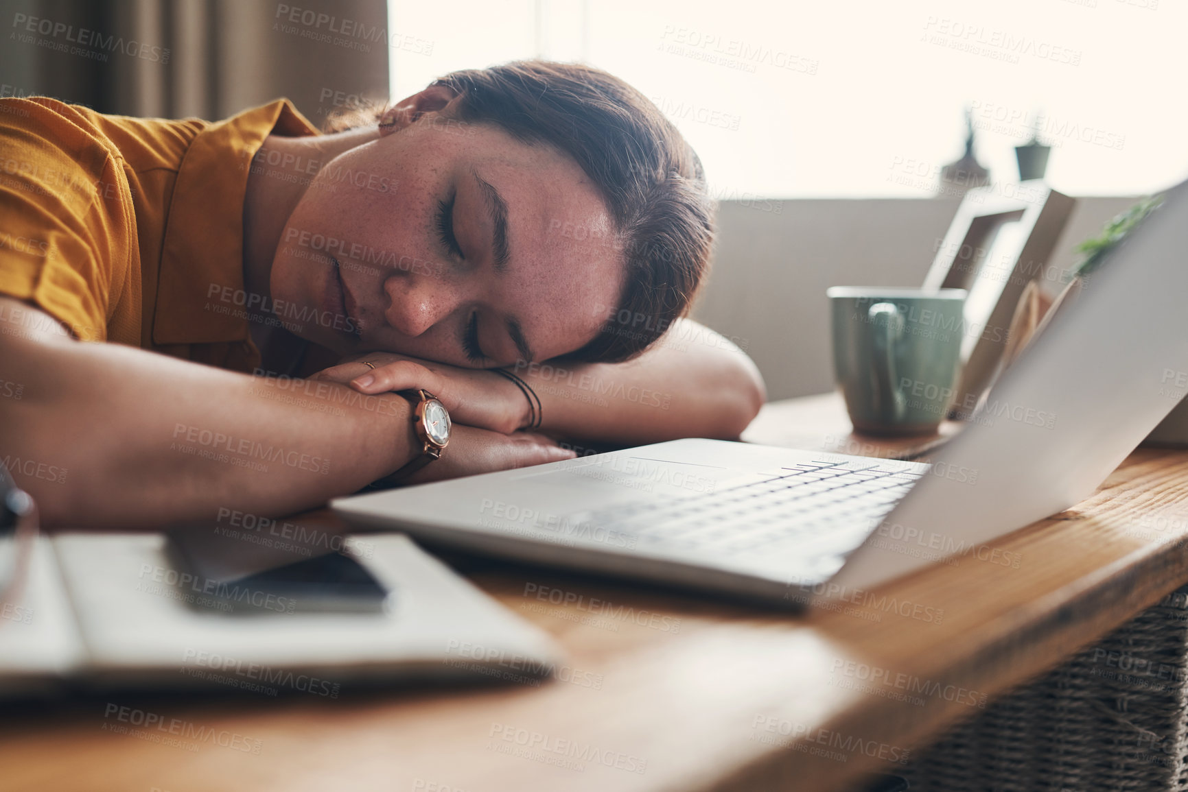 Buy stock photo Shot of a young woman sleeping at her desk while working from home