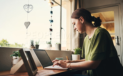 Buy stock photo Shot of a young woman using a laptop while working from home