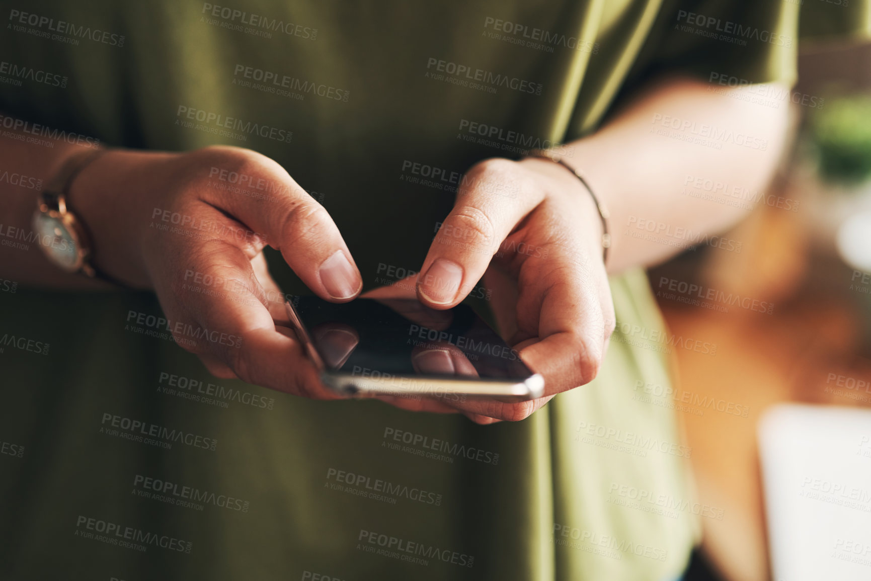 Buy stock photo Shot of an unrecognisable woman using a smartphone while working from home