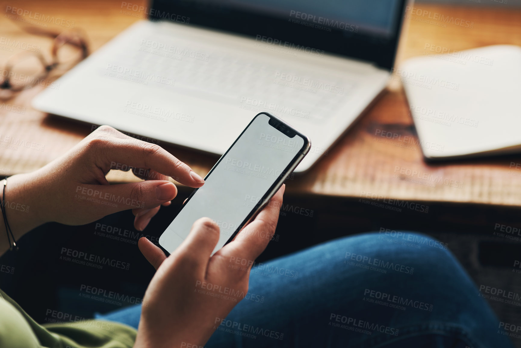 Buy stock photo Cropped shot of a woman using a smartphone while working from home