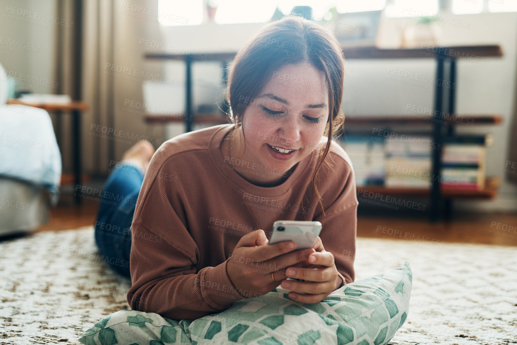 Buy stock photo Woman, smartphone and smile on floor with communication, typing or social media scroll in home living room. Girl, lying and cellphone on carpet for chat, texting or technology with internet in lounge