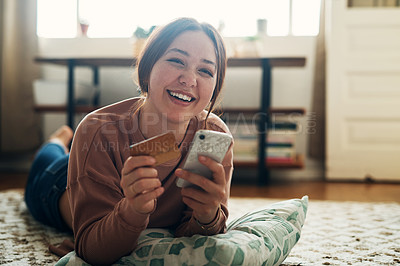 Buy stock photo Shot of a young woman using a smartphone and credit card at home