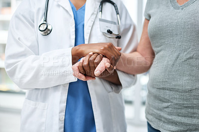 Buy stock photo Shot of an unrecognisable doctor holding hands with a senior patient