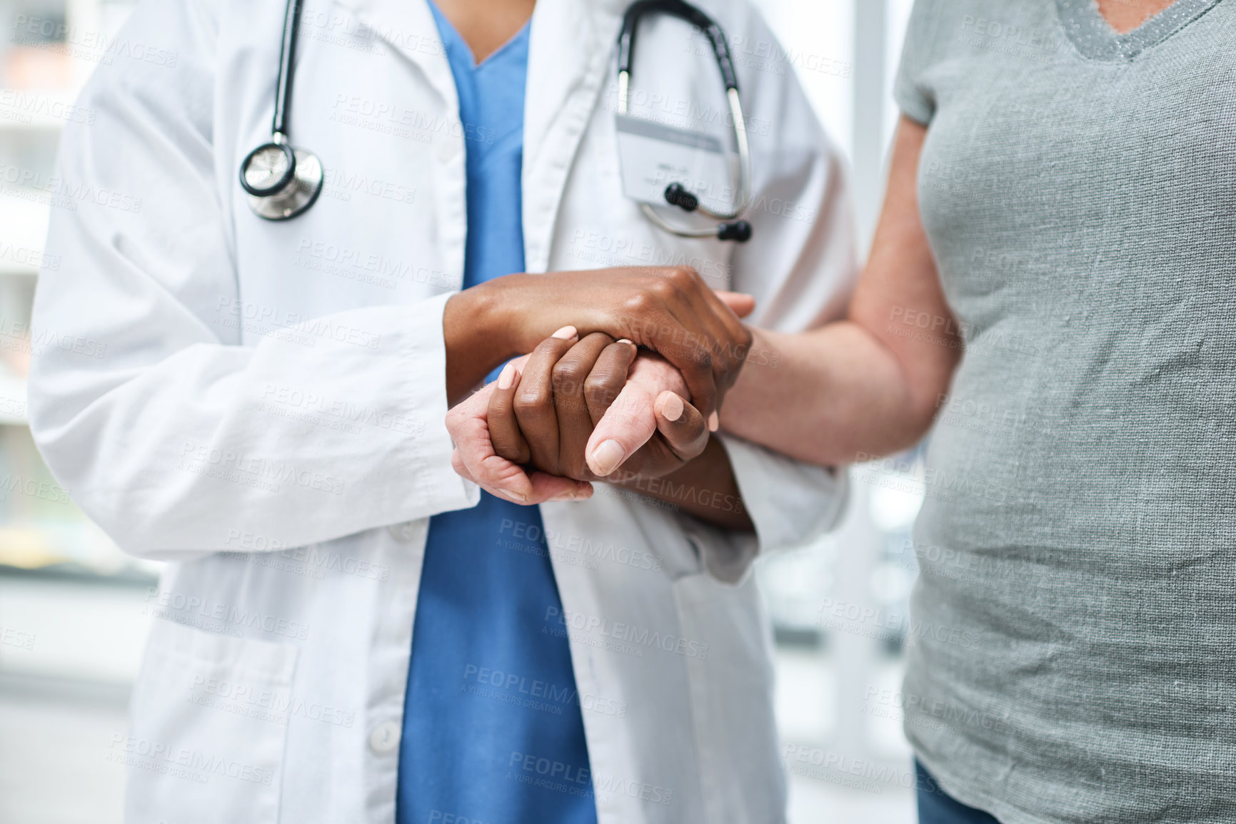 Buy stock photo Shot of an unrecognisable doctor holding hands with a senior patient