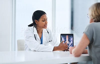 Buy stock photo Shot of a young doctor using a digital tablet during a consultation with a senior woman