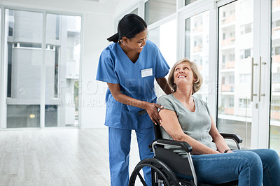 Buy stock photo Shot of a young nurse caring for a senior woman in a wheelchair