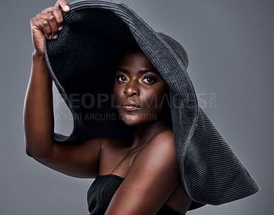 Buy stock photo Shot of a young woman wearing a oversized sunhat against a grey background