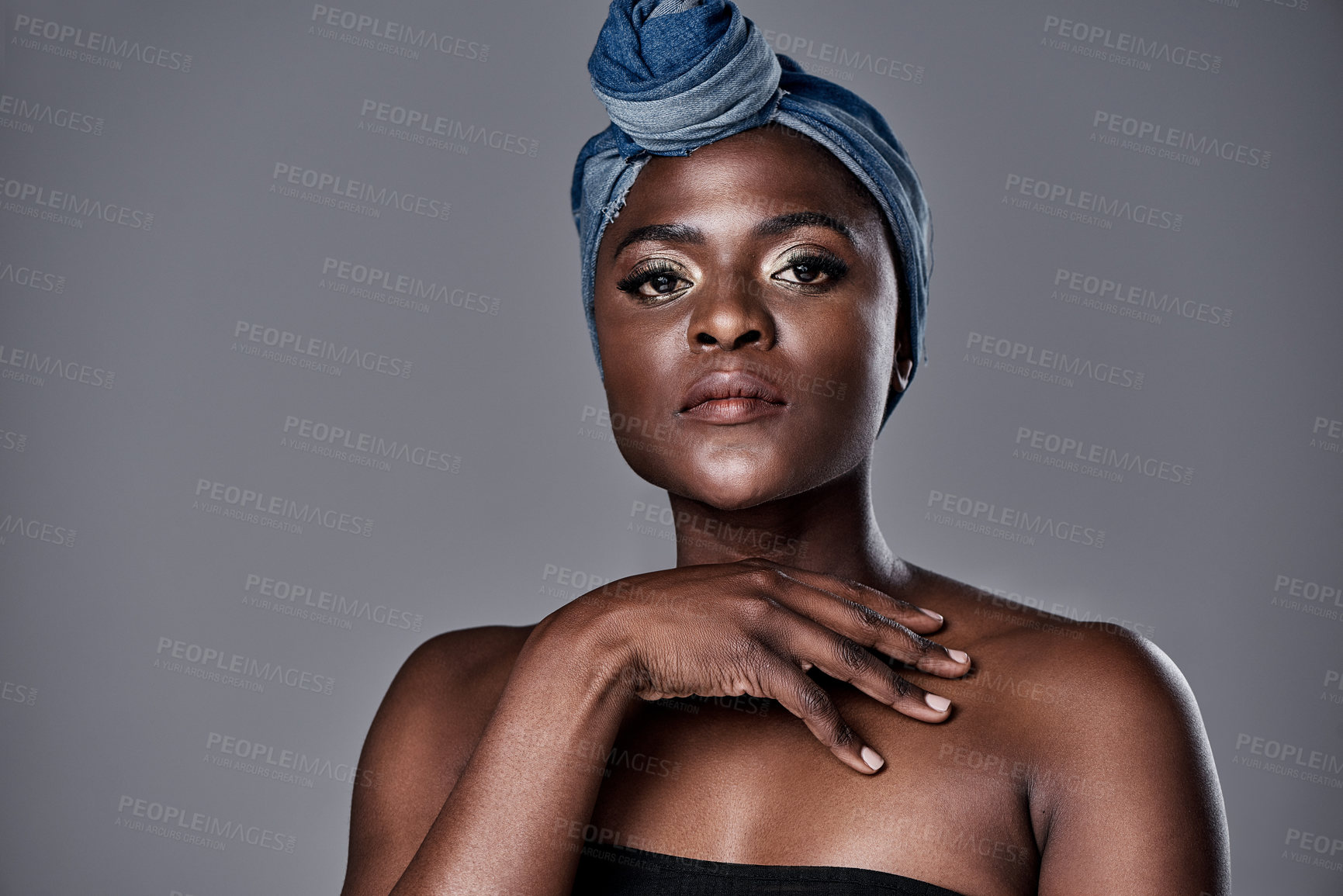 Buy stock photo Shot of a beautiful young woman wearing a denim head wrap while posing against a grey background