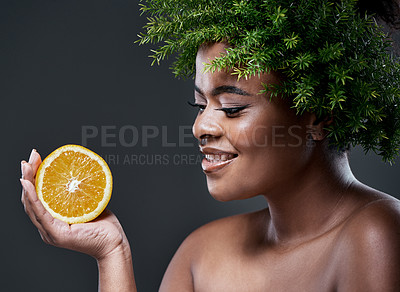 Buy stock photo Shot of a beautiful woman holding an orange and wearing a leaf wreath on her head