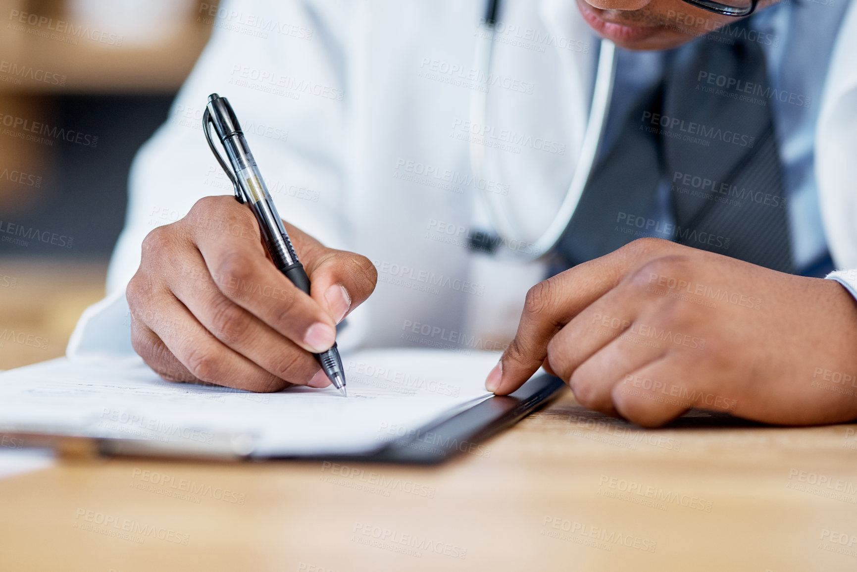Buy stock photo Closeup shot of an unrecognisable doctor writing notes on a clipboard in an office