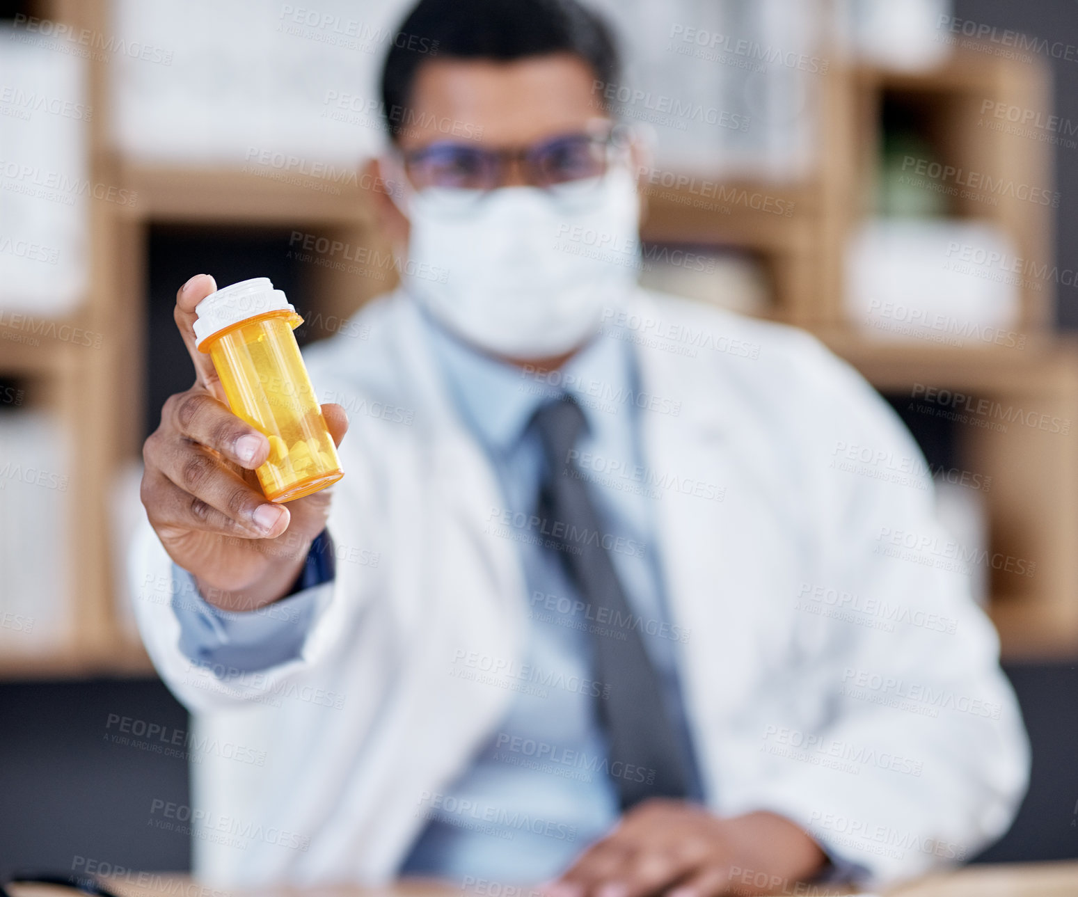 Buy stock photo Closeup shot of an unrecognisable doctor holding a bottle of pills in his office