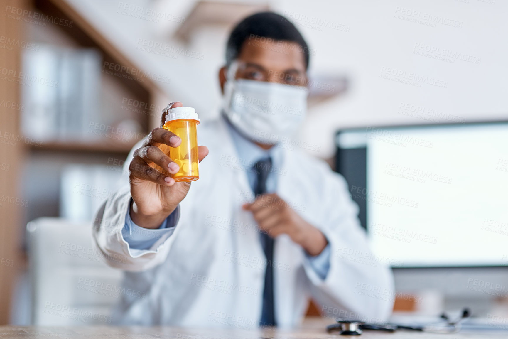 Buy stock photo Closeup shot of an unrecognisable doctor holding a bottle of pills in his office