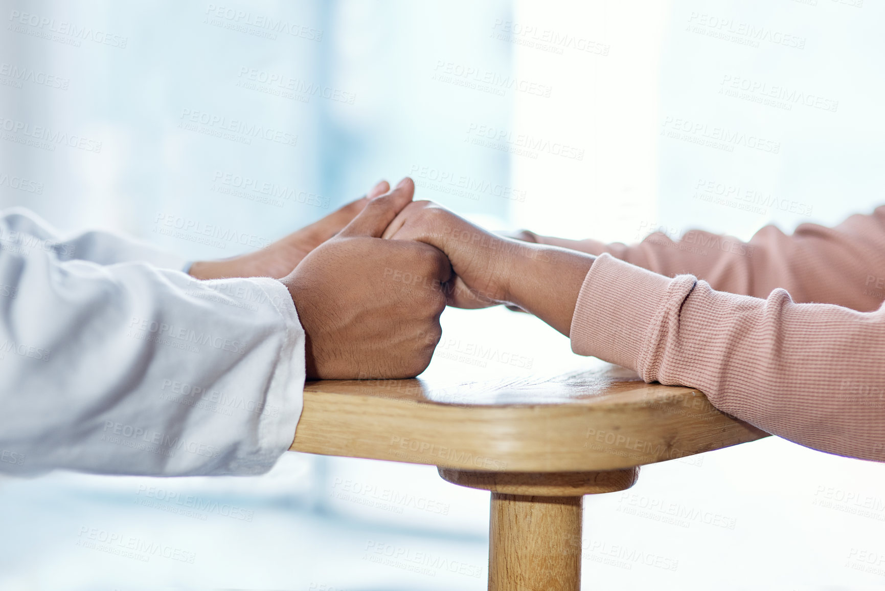 Buy stock photo Closeup shot of an unrecognisable doctor holding hands with a patient during a consultation