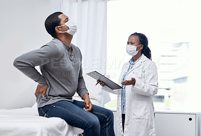 Buy stock photo Shot of a doctor having a consultation with a patient suffering from back pain