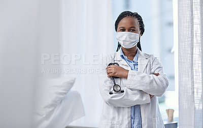 Buy stock photo Portrait of a young doctor wearing a face mask and holding a stethoscope in a hospital