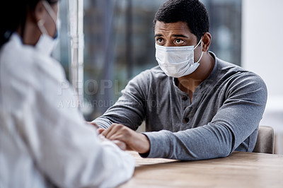 Buy stock photo Shot of a young man holding hands with a doctor during a consultation