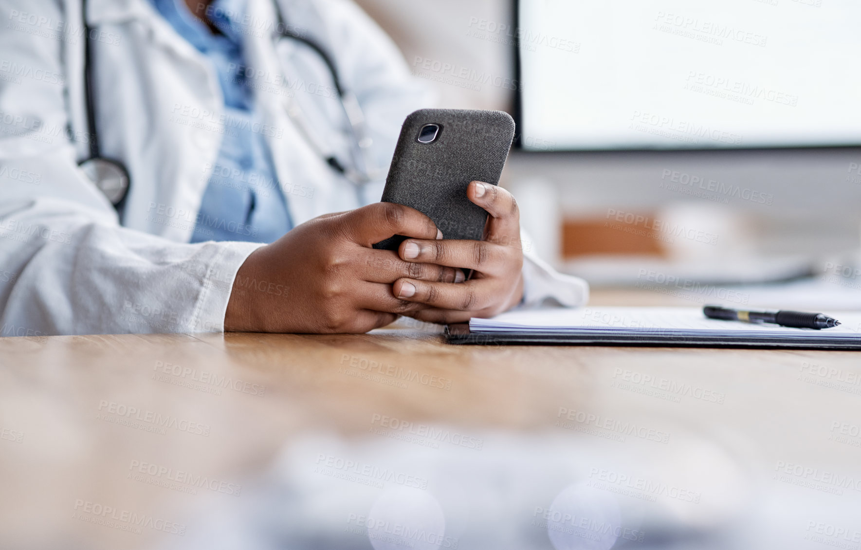 Buy stock photo Closeup shot of an unrecognisable doctor using a cellphone while working in her office