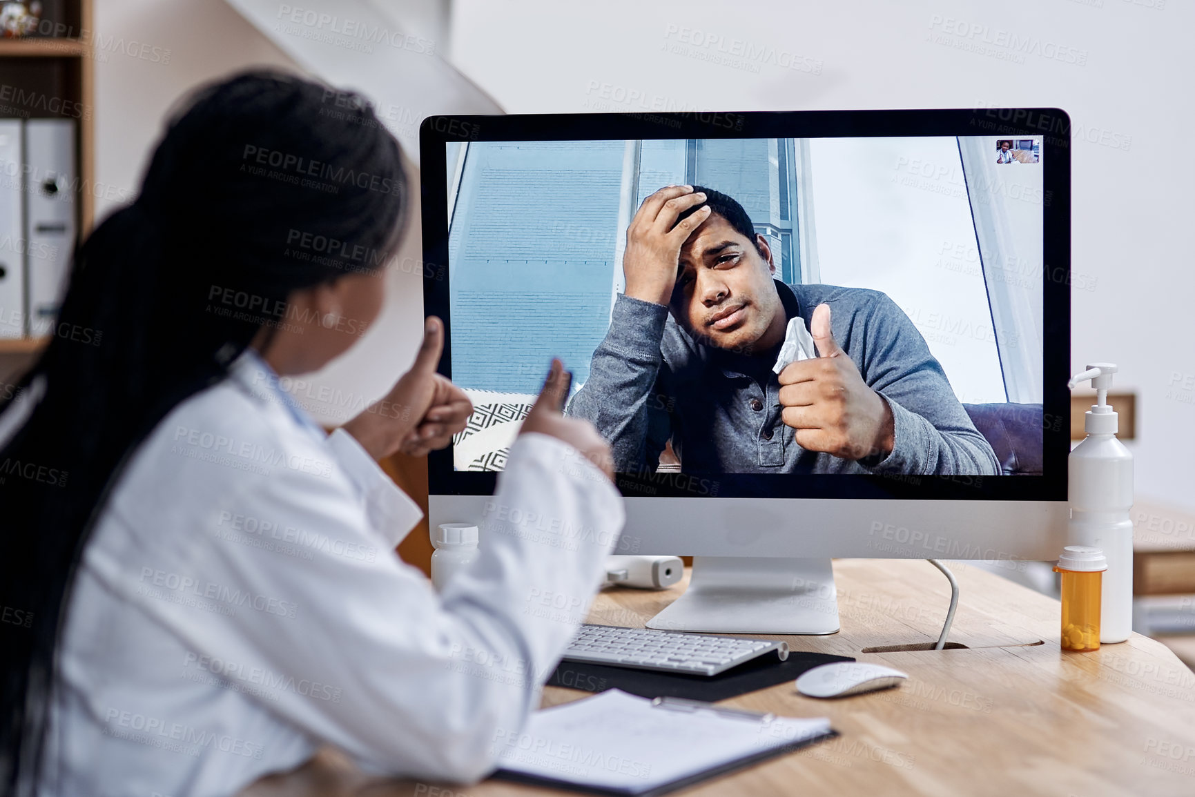 Buy stock photo Shot of a young man showing thumbs up during a video call with a doctor on a computer