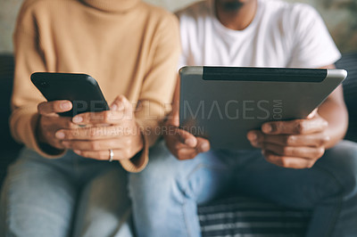 Buy stock photo Closeup shot of an unrecognisable couple using their digital devices at home