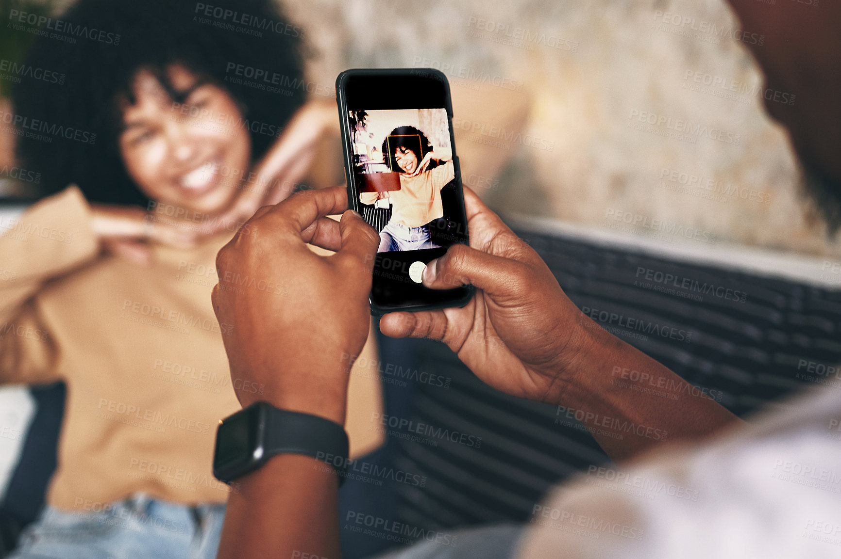 Buy stock photo Shot of a young woman posing while her boyfriend takes photos at home