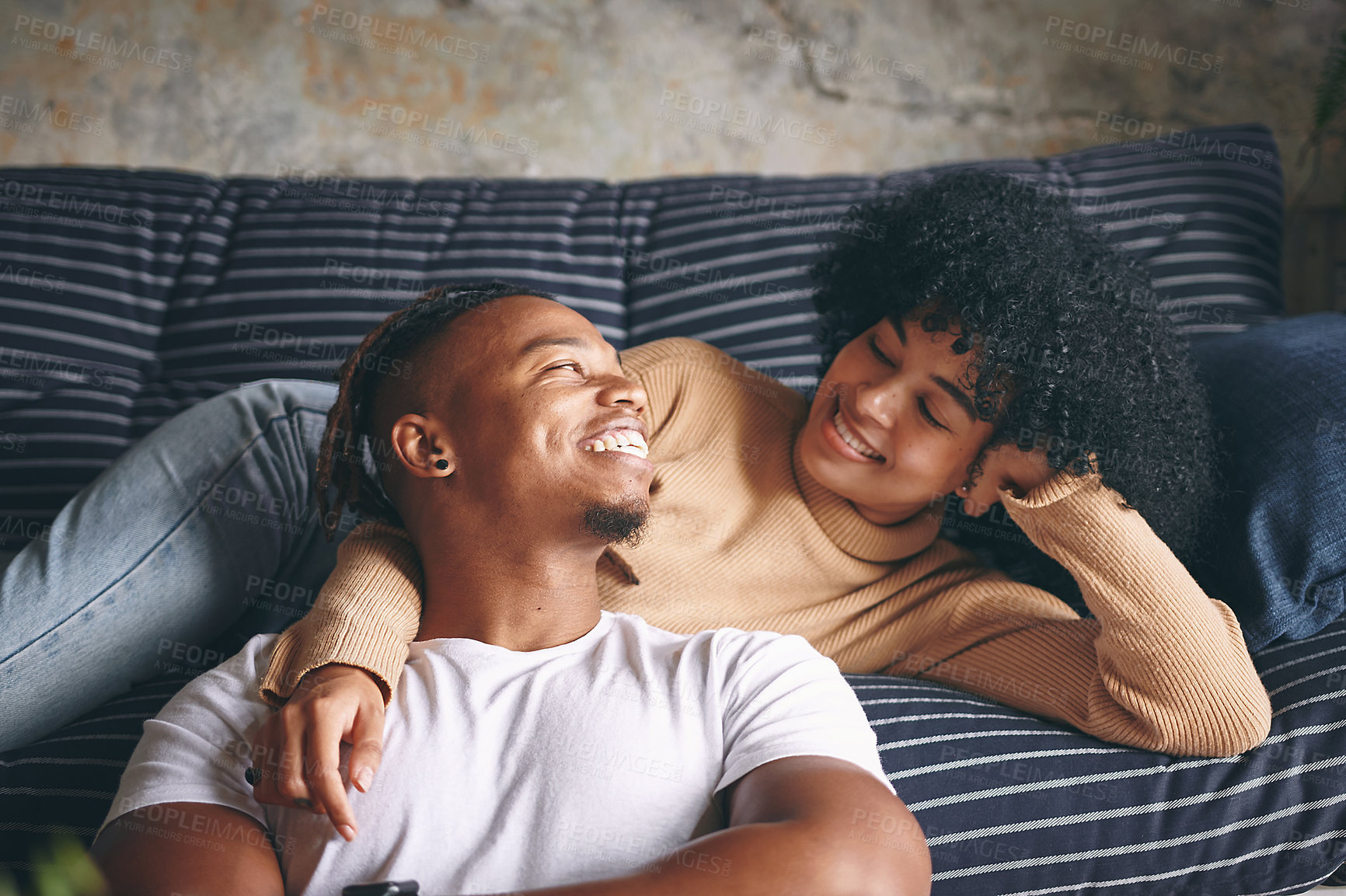 Buy stock photo Shot of a young couple relaxing together at home