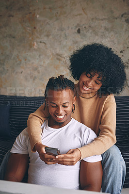 Buy stock photo Shot of a young couple using a cellphone together at home