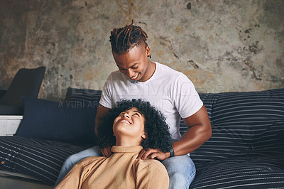 Buy stock photo Shot of a young man massaging his girlfriend's shoulders at home