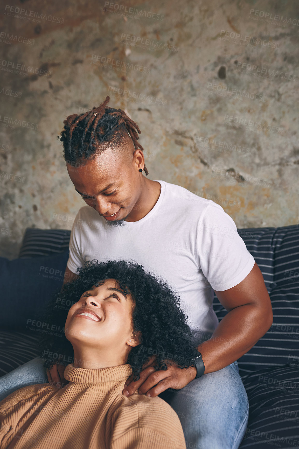 Buy stock photo Shot of a young man massaging his girlfriend's shoulders at home