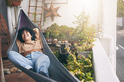 Buy stock photo Shot of a young woman relaxing on a hammock outdoors