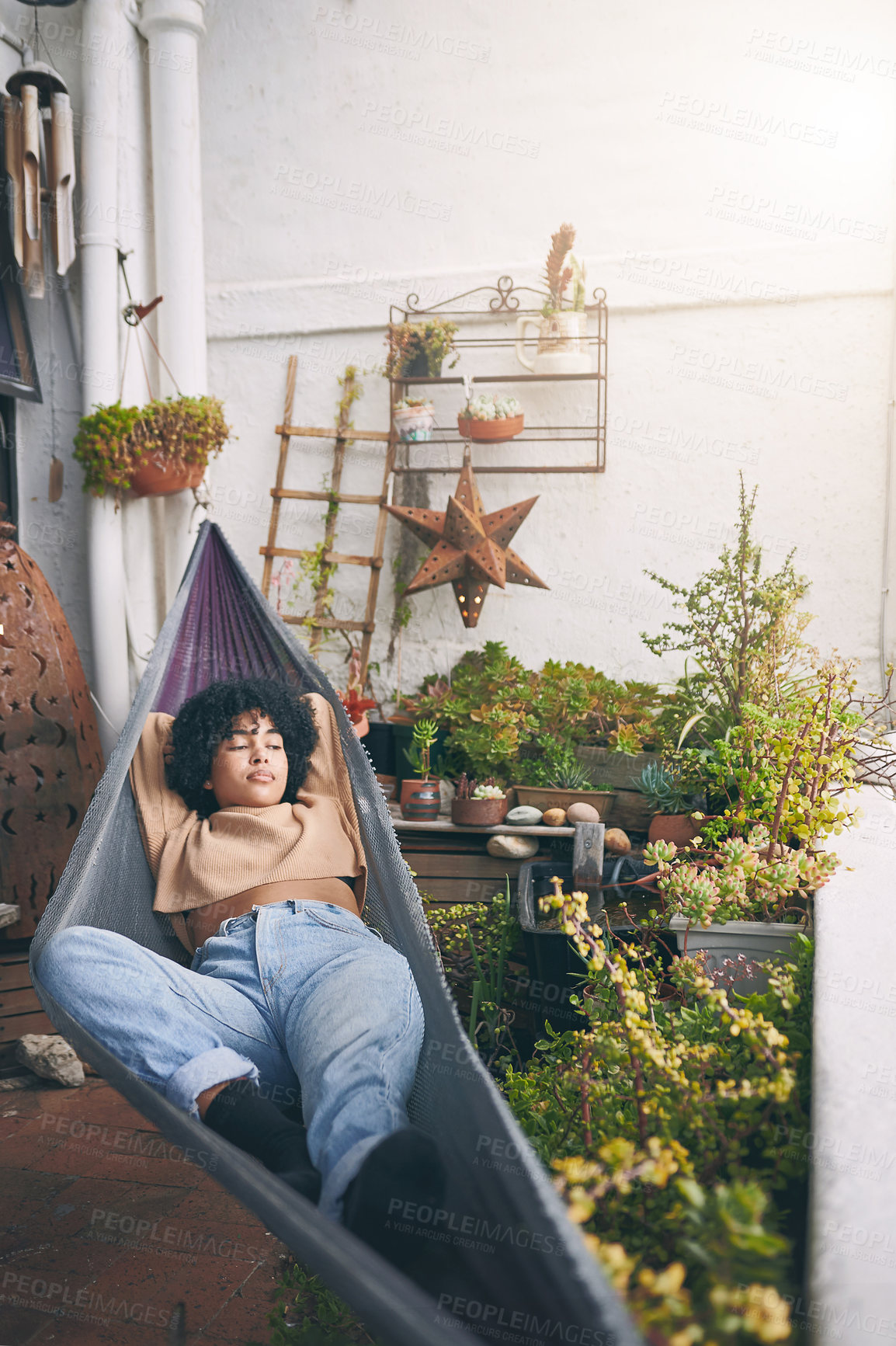 Buy stock photo Shot of a young woman relaxing on a hammock outdoors