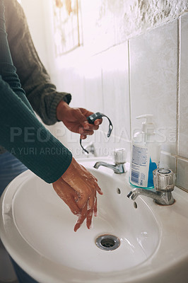 Buy stock photo Closeup shot of an unrecognisable woman washing her hands while being timed with a watch in a bathroom at home