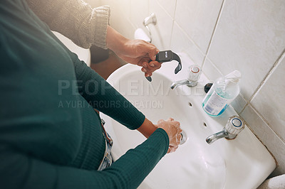 Buy stock photo Closeup shot of an unrecognisable woman washing her hands while being timed with a watch in a bathroom at home