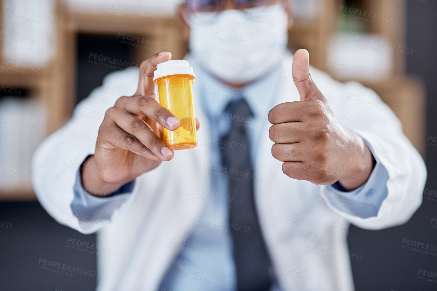 Buy stock photo Closeup shot of an unrecognisable doctor holding a bottle of pills and showing thumbs up in his office