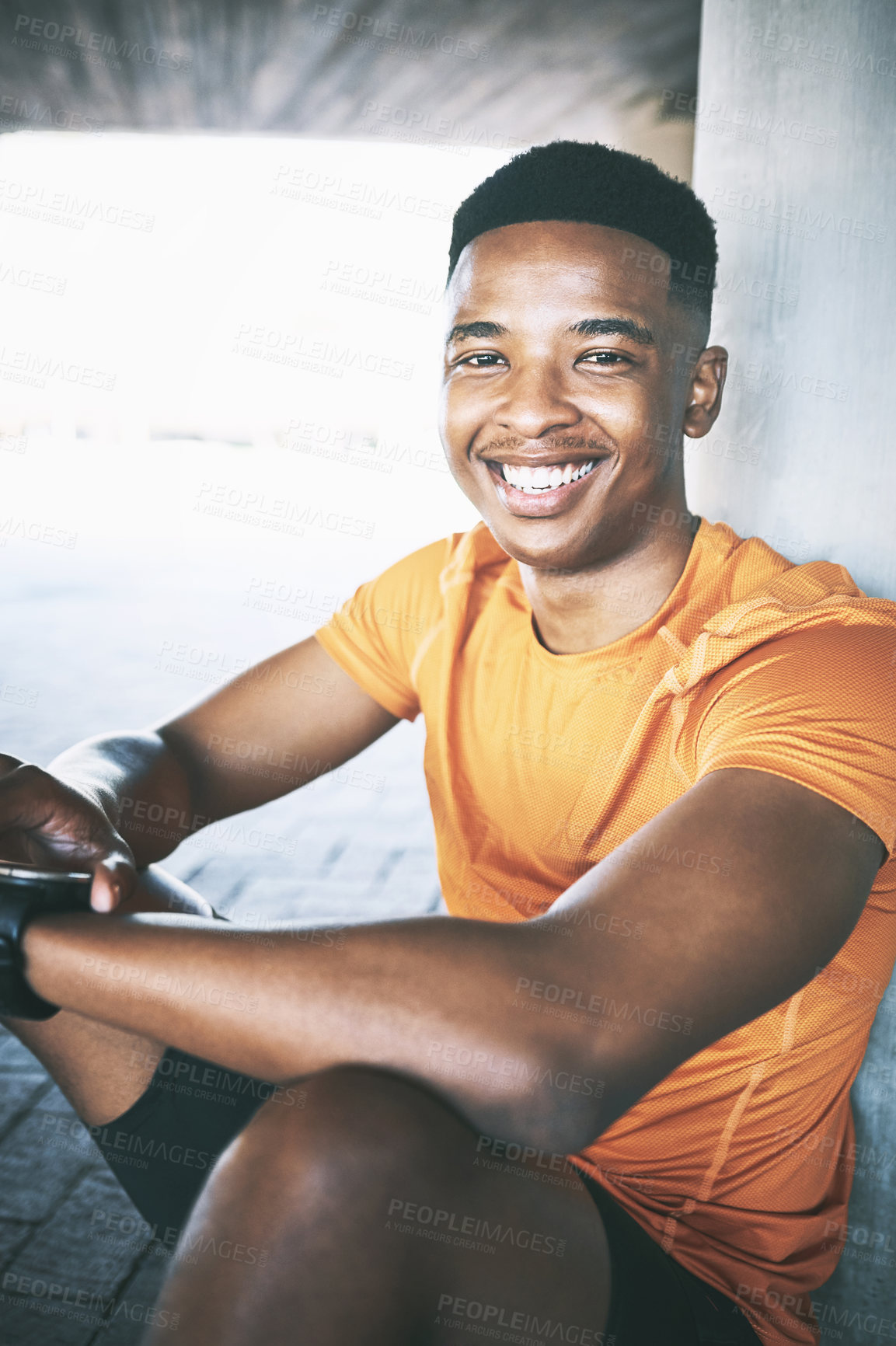 Buy stock photo Portrait of a young man looking at his watch during a workout against an urban background