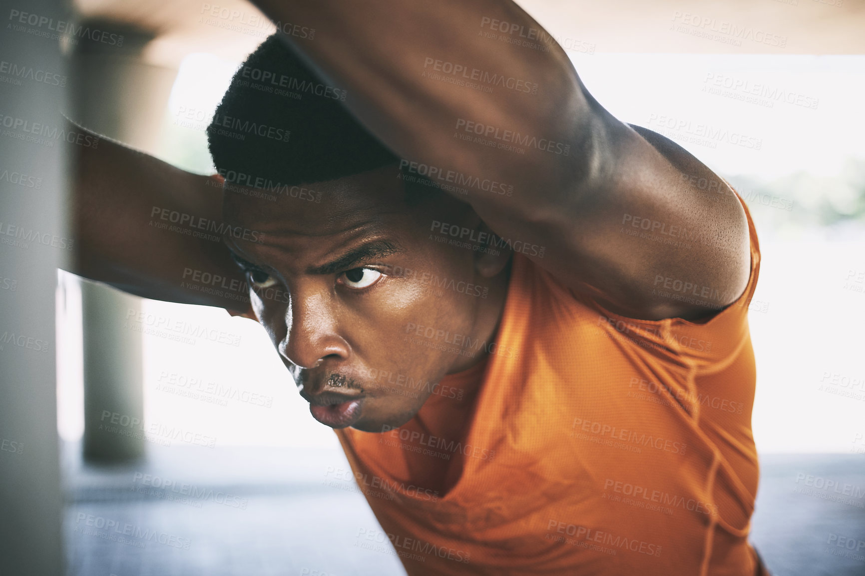 Buy stock photo Shot of a young man stretching during a workout against an urban background