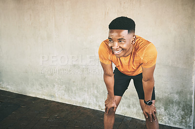 Buy stock photo Shot of a young man taking a break after working out against an urban background