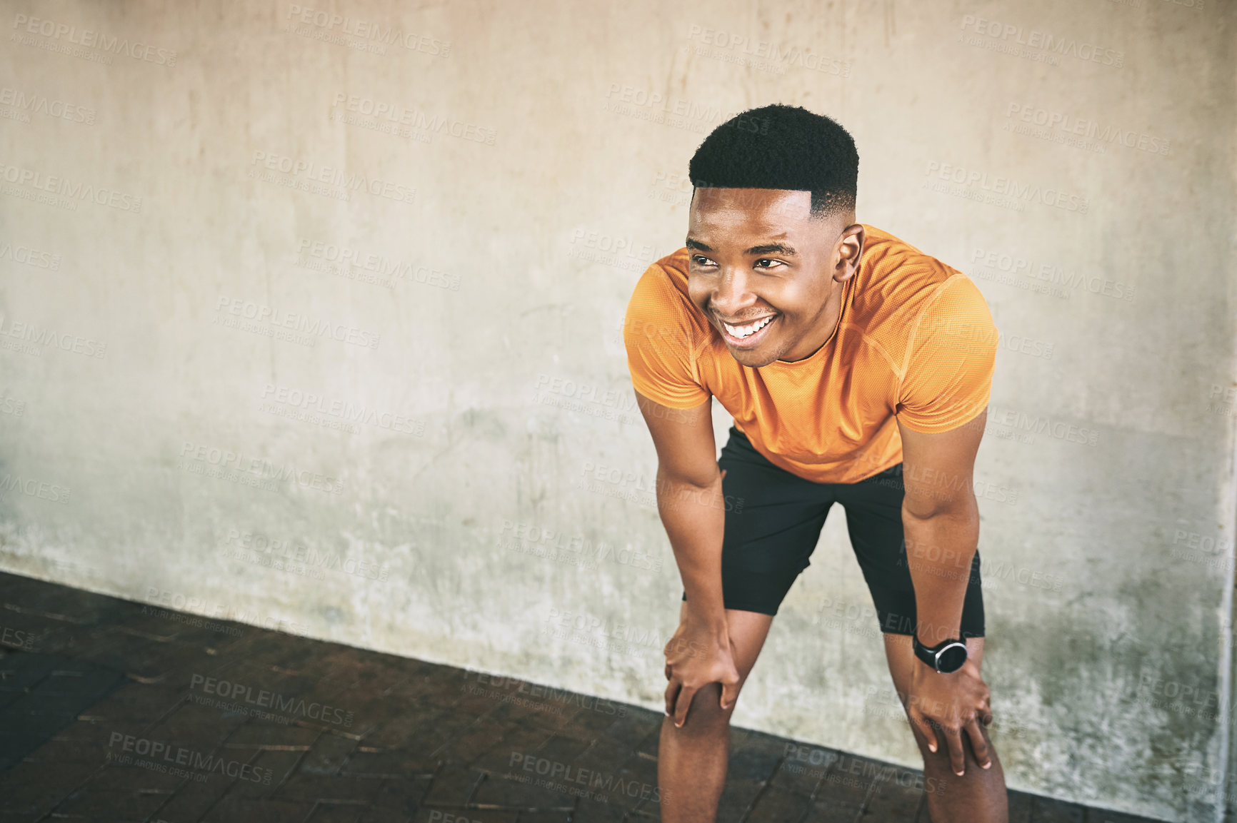 Buy stock photo Shot of a young man taking a break after working out against an urban background