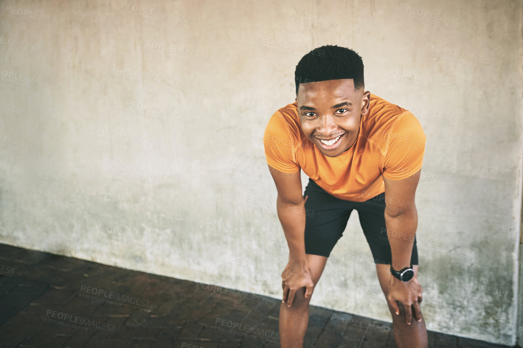 Buy stock photo Shot of a young man taking a break after working out against an urban background