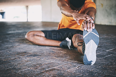 Buy stock photo Cropped shot of a man stretching during a workout against an urban background