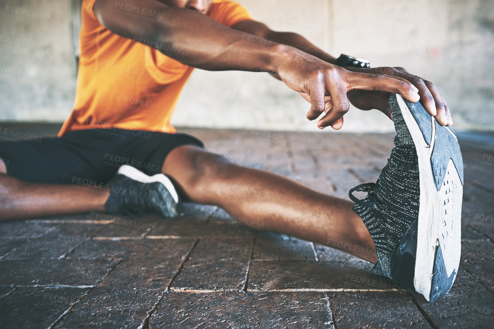 Buy stock photo Cropped shot of a man stretching during a workout against an urban background