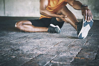 Buy stock photo Cropped shot of a man stretching during a workout against an urban background