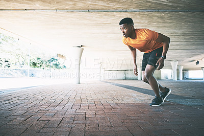 Buy stock photo Shot of a young man going for a run against an urban background