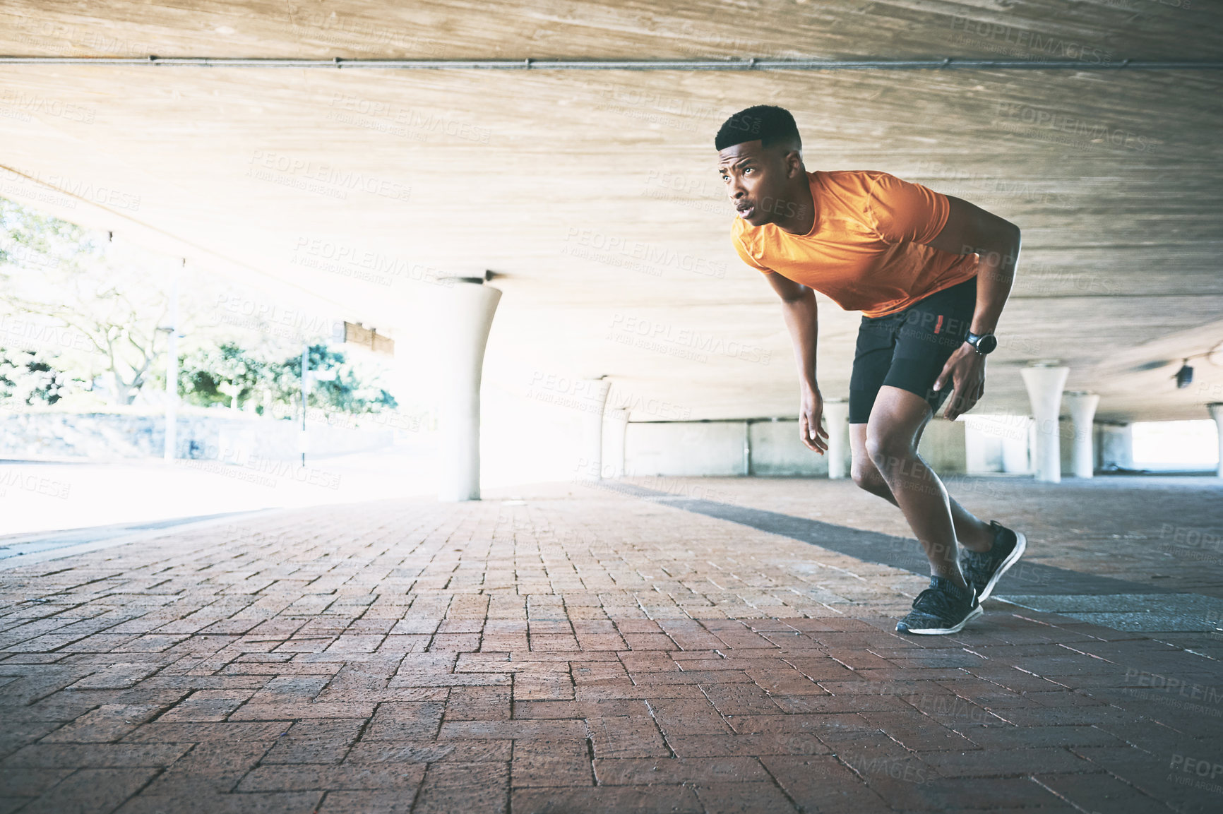 Buy stock photo Shot of a young man going for a run against an urban background