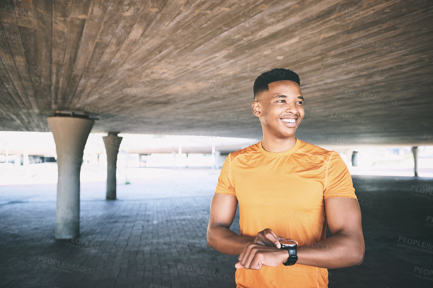 Buy stock photo Shot of a man looking at his watch during a workout against an urban background