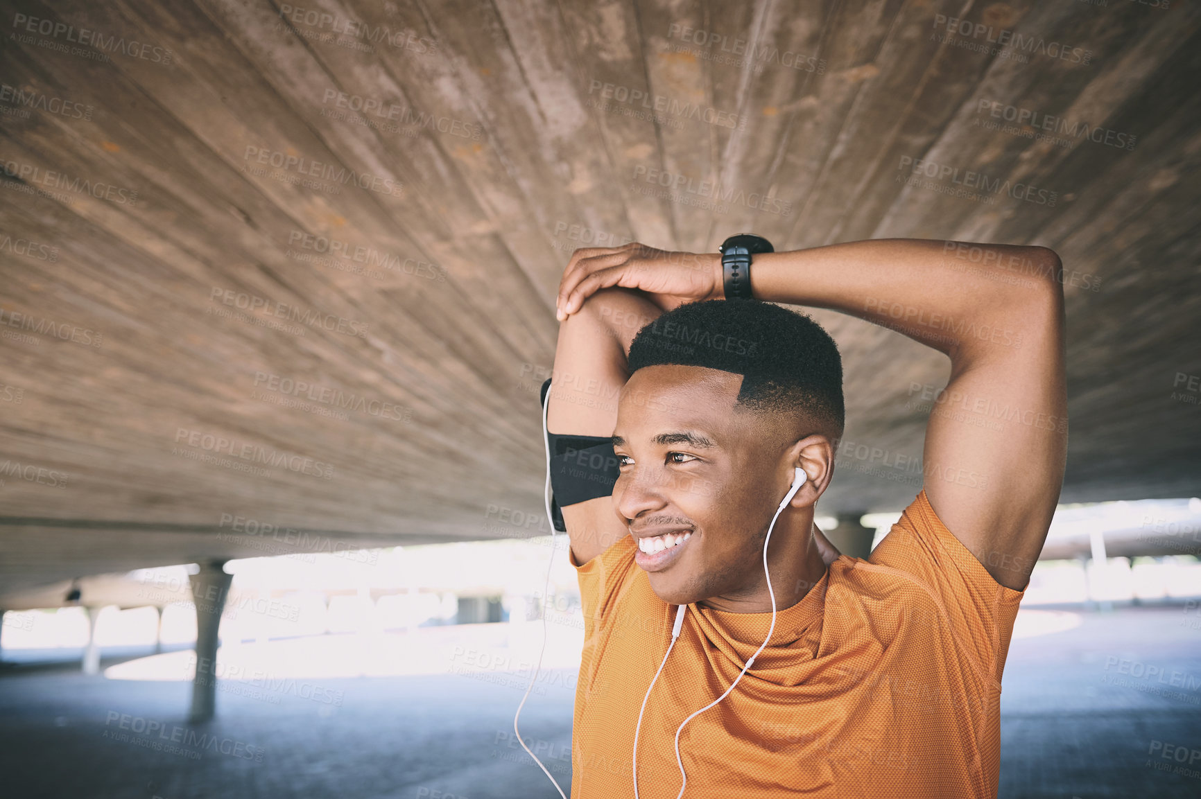 Buy stock photo Shot of a young man stretching during a workout against an urban background