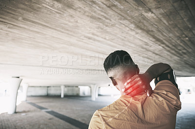 Buy stock photo Rearview shot of a young man experiencing neck pain while working out against an urban background